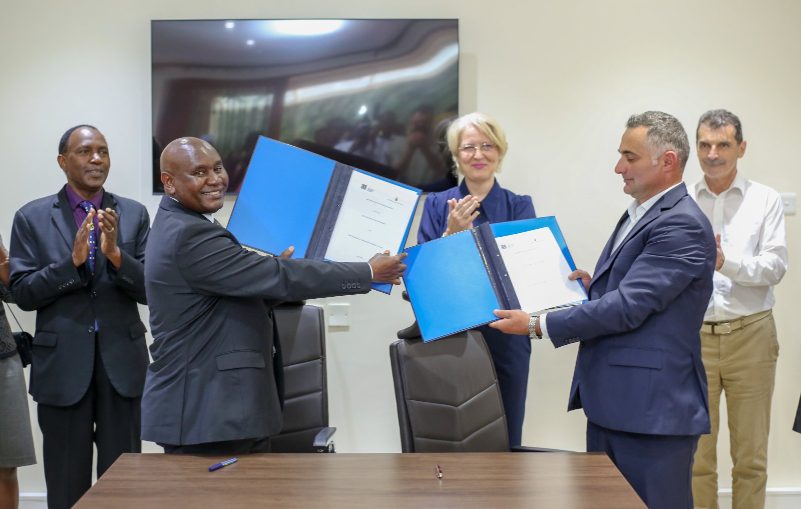 VC, Prof. Benedict Mutua (2nd L) and Transilvania University of Bra\u0219ov Dean, Faculty of Furniture Design and Wood Engineering, Prof. Alin OL\u0102RESCU (2nd R) presents the signed MoU. Present during the occasion was DVC -IAE Prof. Paul Wambua (L) and Romanian Ambassador to Kenya, H.E Gentiana Serbu (3rd R) among other guests.
